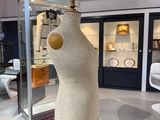 a mannequin on a stand in a room with a red ceiling