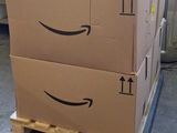 boxes stacked on pallets with arrows pointing to the amazon logo