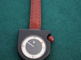a black and white watch on a brown strap