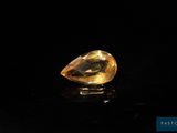 a yellow sapphire stone on a black surface