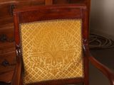 a wooden chair with a yellow upholstered cushion on it