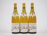 trois bouteilles de vin posées les unes à côté des autres sur une surface blanche