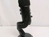 a black microphone on a stand with a white background