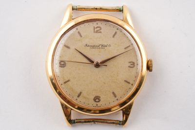 une image d'une montre-bracelet en or sur une surface blanche