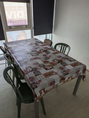 une table et des chaises dans une pièce avec une fenêtre en arrière-plan