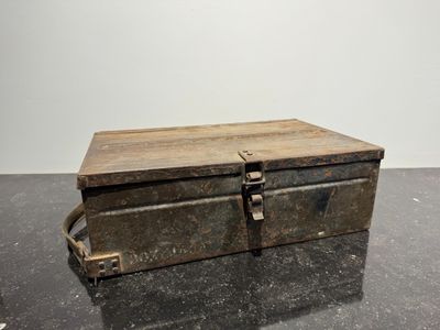 an old metal box sitting on top of a black table