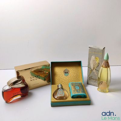 trois parfums différents dans une boîte posée sur une table