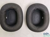pair of black ear cushions for a pair of headphones on a white surface