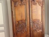 a wooden armoire in the corner of a room