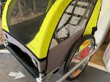 une poussette pour enfant fixée à une remorque de vélo