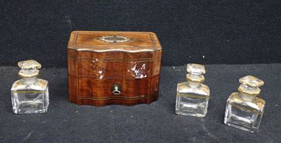 a small wooden box with three bottles of perfume on a table