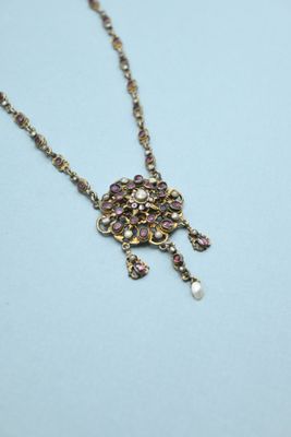 a close up of a necklace on a blue surface