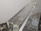 a clear acrylic object on a black and white marble floor