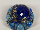 a close up of a glass vase with a blue and gold design