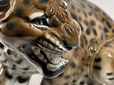 a figurine of a cheetah on a white surface