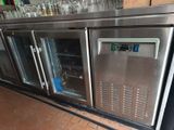 a metal counter with a bunch of bottles on it