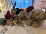 many stuffed animals sitting on a bed together