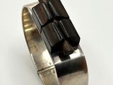 silver ring with black stones on it on a white surface