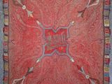 a red and blue rug with a decorative design on it