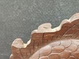 a wooden carving of a fish on a table