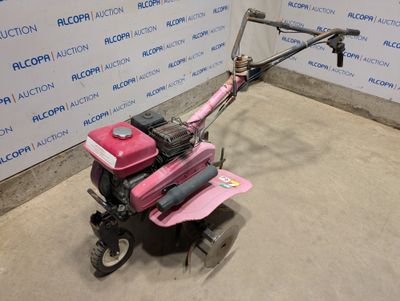 a small pink lawn mower sitting in a room