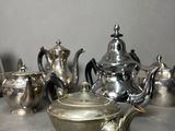 a lot of silver teapots sitting on a table