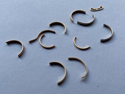six paires de piercings au nez sur un fond bleu