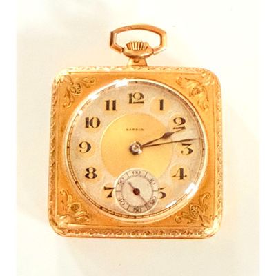 une montre de poche en or avec des chiffres romains sur le cadran