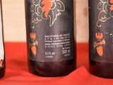 three bottles of wine sitting on a red cloth