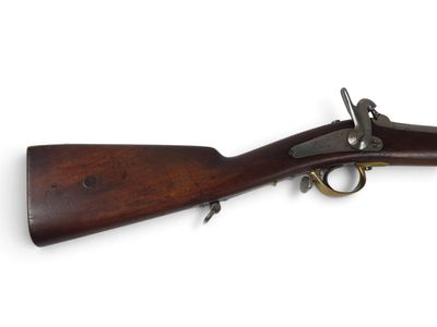 un vieux fusil avec un canon en bois et des garnitures en laiton