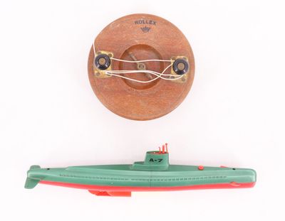 un sous-marin miniature et un bateau miniature posés sur une surface blanche