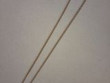 a close up of a long chain with a glass pendant on it