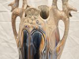 a vase that is sitting on a stand on a table