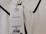 the white shirt has a black collar and a tag on it