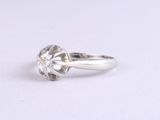 a close up of a diamond ring on a white surface