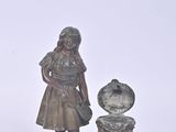 a statue of a girl and a dog on a plate