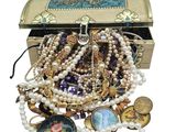 a chest full of assorted jewelry on a white background