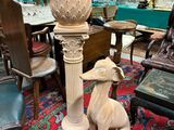 a statue of a dog sitting next to a lamp on a table