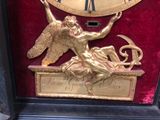 a gold clock with an angel on top of it