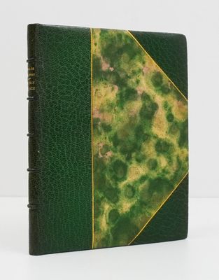 an old book with a green cover and gold trim