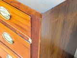 a wooden dresser with brass handles on it