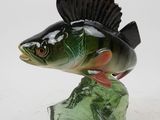 statue of a fish on a rock on a white surface