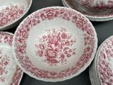 several red and white plates and bowls are arranged on a table