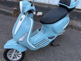 un scooter bleu garé devant un immeuble