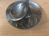 a silver plate with a spoon on it on a wooden table