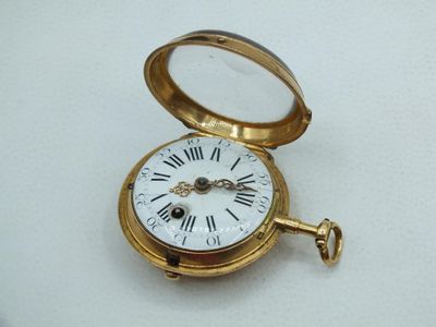 a gold pocket watch with roman numerals on it
