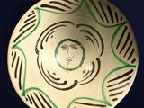 a bowl with a face painted on the side of it