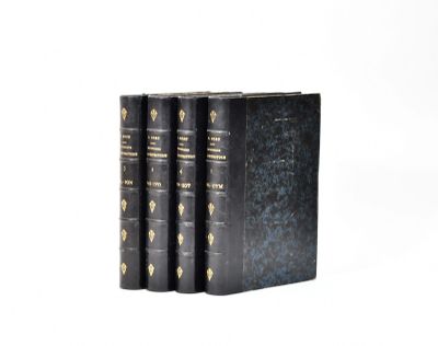three black books with gold trims on them sitting on a white surface