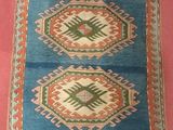 une image représentant un tapis bleu et orange sur fond rose
