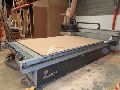 une photo d'une machine en train de découper une plaque de bois